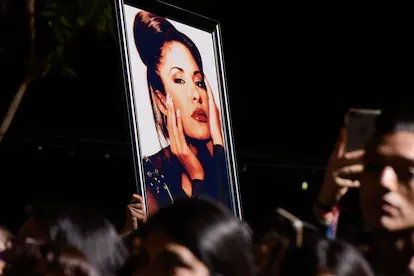 Fans hols a photo of Selena during the ceremony honoring singer Selena Quintanilla with a Star on the Hollywood Walk of Fame on November 3, 2017, in Hollywood, California. / AFP PHOTO / TARA ZIEMBA (P