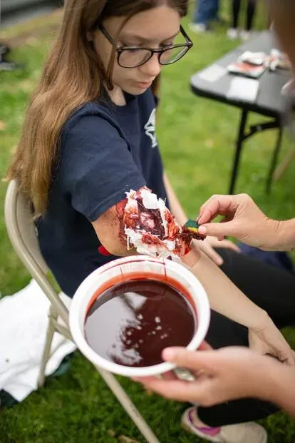 La estudiante Lainey, mientras le fabrican una herida simulada en el brazo.