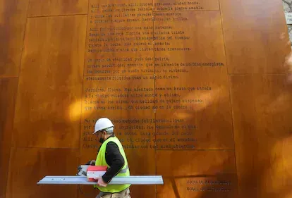 Un operario retira planchas con erratas en un poema de Vicente Aleixandre, en Málaga en 2020.