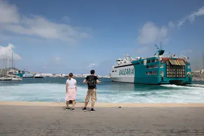 Unos turistas contemplan la salida de uno de los ferrys que atracan en Ibiza el pasado jueves.