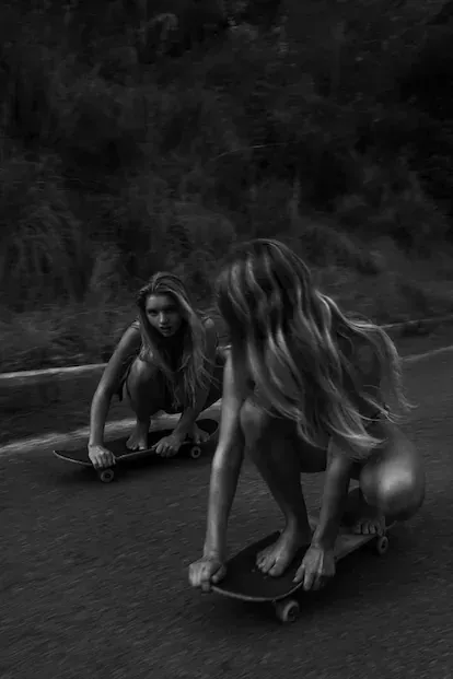 Dos amigas de la fotógrafa bajan en skate hacia la playa.