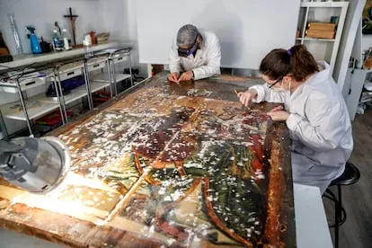 Dos miembros del equipo del restaurador Pablo Nieto y del estudio El Parteluz (Albacete) restauran 'La misa de san Gregorio'.