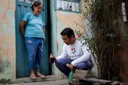 Un voluntario de Mundo Sano revisa elementos que pueden almacenar agua de lluvia, allí donde el mosquito  'Aedes aegypti' deposita sus huevos.