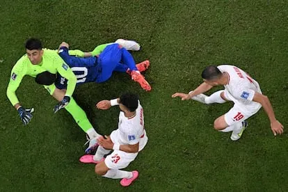 El delantero estadounidense Christian Pulisic choca con el portero iraní, Alireza Beiranvand, depués de marcar el primer gol del encuentro.