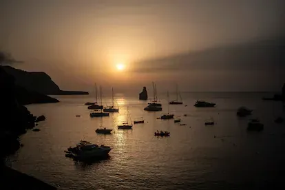 Barcos fondeados al tardecer en la cala Benirrás, Ibiza.