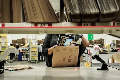 Una empleada de Amazon introduce un libro para su envío en los almacenes de la compañía en Brieselang, Alemania.