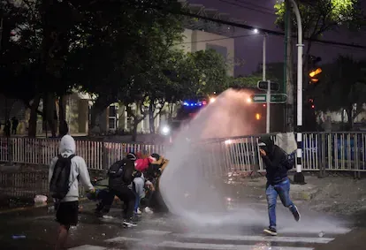 Manifestantes se enfrentan a la policía afuera del estadio Romelio Martínez de Barranquilla durante un partido de Copa Libertadores entre el América de Cali y el Atlético Mineiro.