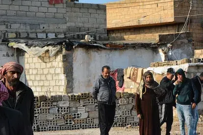 Alia Hasan, de 52 años, junto a su hijo Faruk y algunos vecinos en frente de lo que era su casa. Solo una habitación resistió a los ataques y acaba de ponerle un toldo con el fin de protegerse del frí