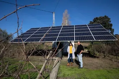 Federico Schatz, vitivinicultor, y su pareja Raquel Elia, de la Asociacion Salvemos Campos y Montes, frente a una placa fotovoltaica.