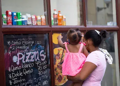 Una madre y su bebé observan el escaparate de una cafetería.