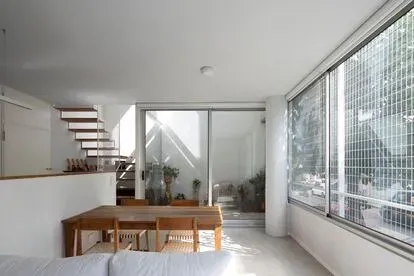 La vegetación, un tilo, penetra en la vivienda gracias a su apertura al exterior.
