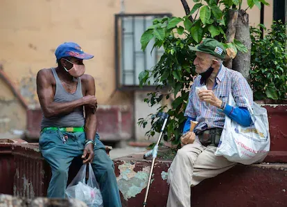 Dos hombres conversan en un parque de la calle Obispo.