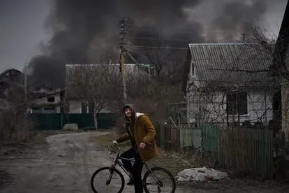 Un joven en bicicleta durante los bombardeos en Irpin, este domingo.