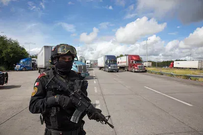 Un elemento de la policía estatal del estado de Nuevo León "Fuerza Civil" vigila a la altura de la caseta de cobro en Sabinas Hidalgo, Nuevo León.