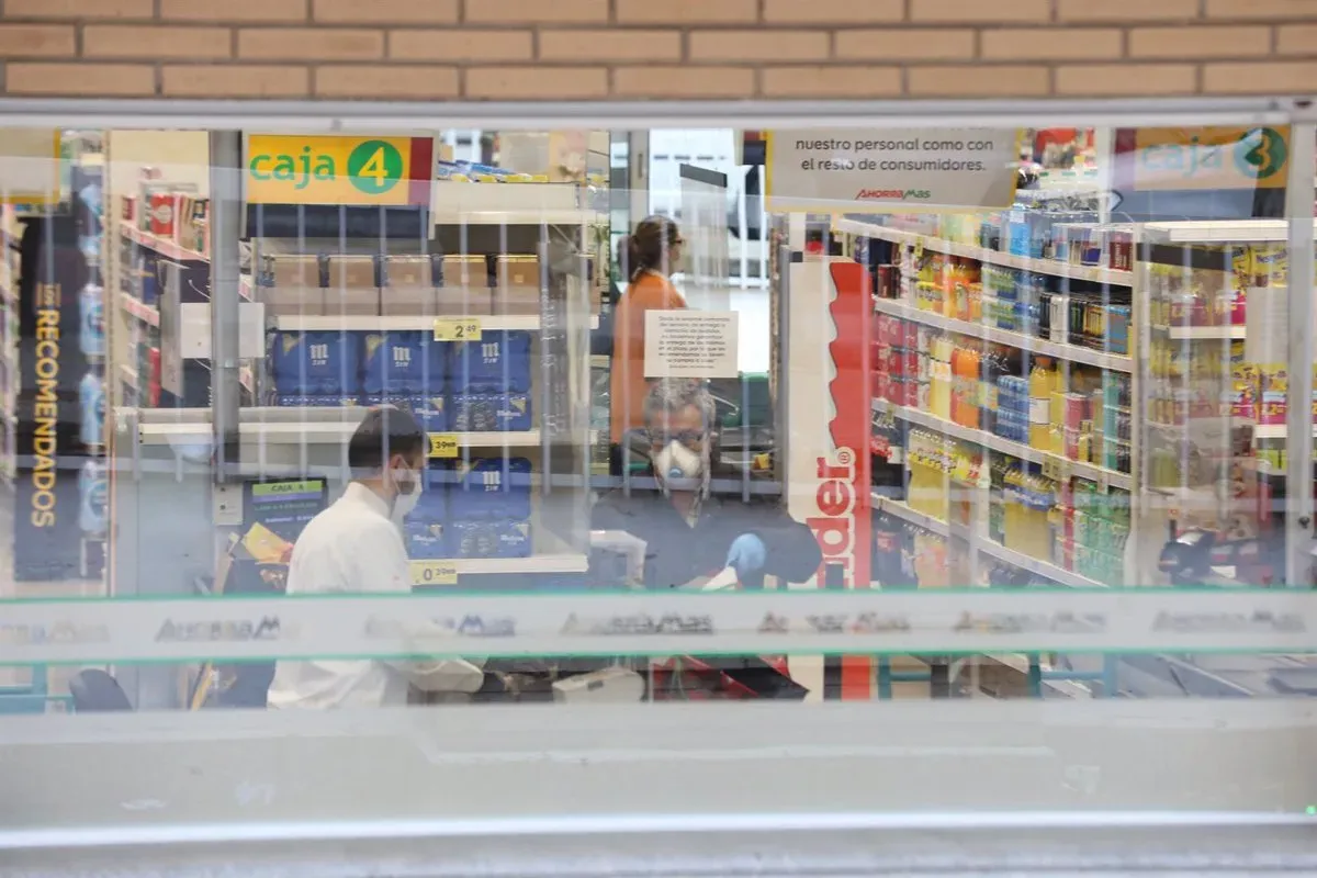 23/03/2020 Un cajero de un supermercado AhorraMas trabaja protegido con mascarilla en plena crisis sanitaria. Europa Press