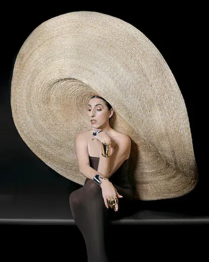 Pulseras Bone Cuff en oro y plata, creación que en 2019 cumplió 50 años y probablemente sea el diseño más icónico de Elsa Peretti para Tiffany & Co. Sombrero de paja natural de Eliurpi y vestido tubo 