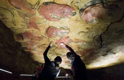 Unos turistas observan las pinturas rupestres en la réplica de las Cuevas de Altamira, situada en la localidad cántabra de Santillana del Mar.