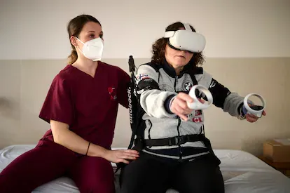 La paciente Estíbaliz Zabalza realiza un ejercicio con el exoesqueleto y las gafas de realidad virtual.