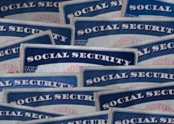 a selection of Social Security cards on a darkened background