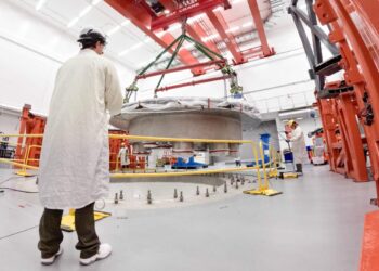 Commonwealth Fusion Systems employees supervise the installation of the tokamak's cryostat base.