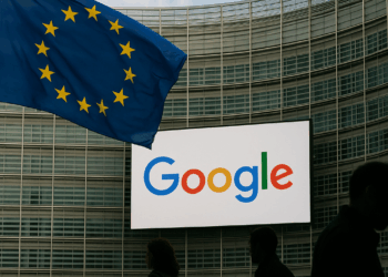 European Union flag displayed on a laptop screen and Google logo displayed on a phone in front of it