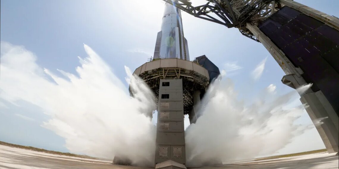 A view of SpaceX's starship system on the launchpad with the water-cooling flame deflector system active